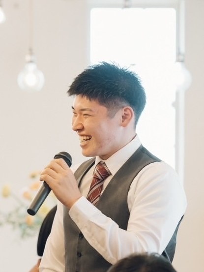 マイクを持って笑っている加藤滉大